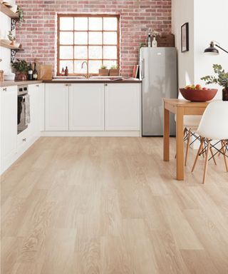 wooden effect luxury vinyl flooring in kitchen with white cabinets