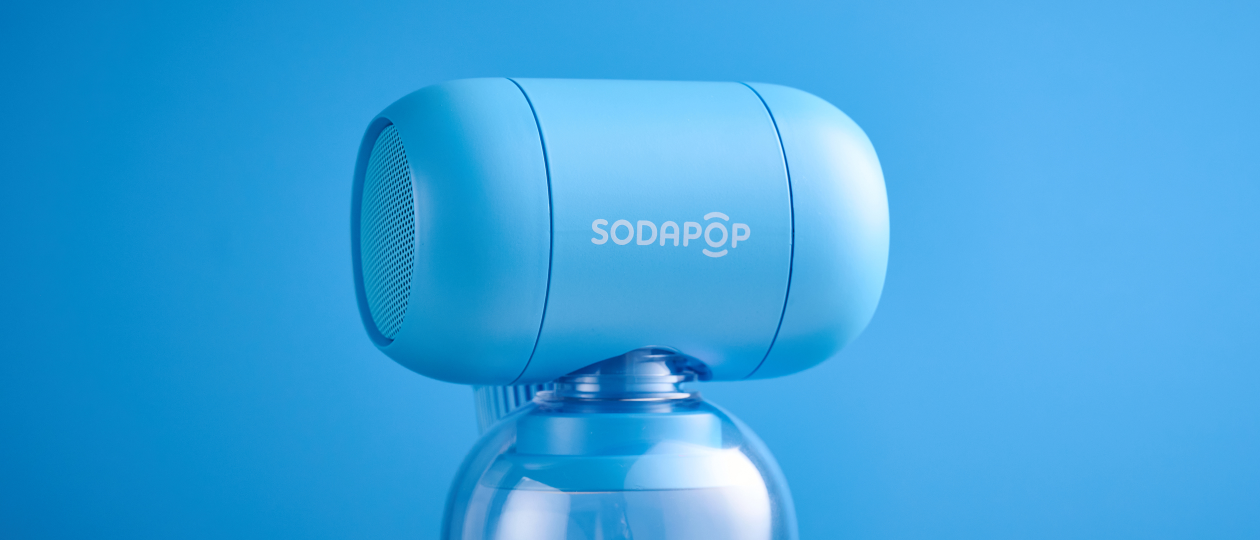 A blue Sodapop Bluetooth speaker that screws onto any regular-sized bottle