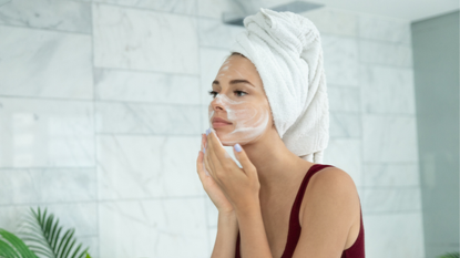 How to cleanse your face - woman washing her face looking in the mirror