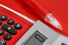 Red pen and a calculator showing zero on a red background
