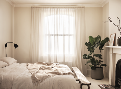 neutral bedroom with a bench at the end of the bed