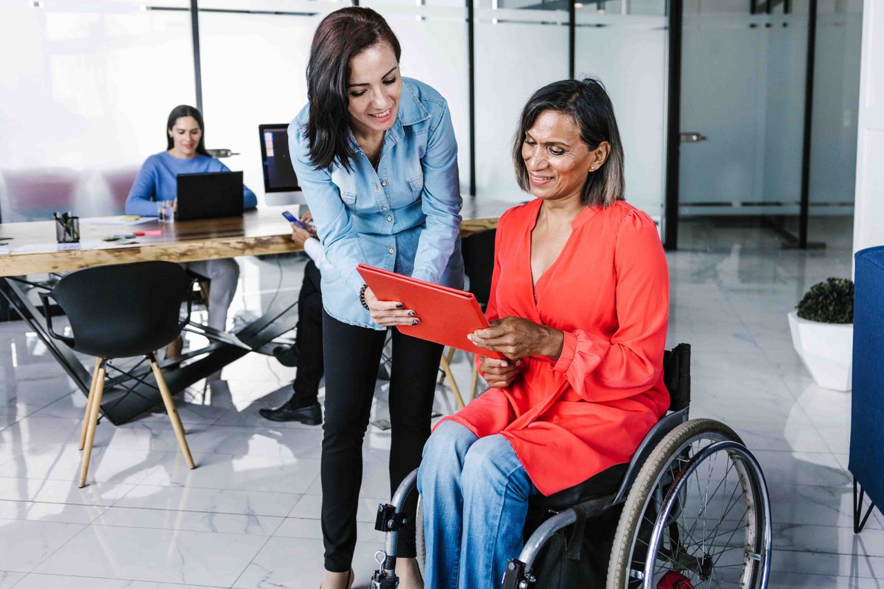 worker in wheelchair talking to colleague