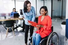 worker in wheelchair talking to colleague