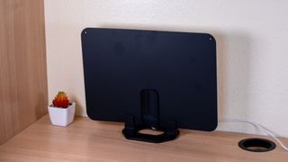 The Best Buy Essentials Ultra-Thin Amplified HDTV Antenna on a desk.