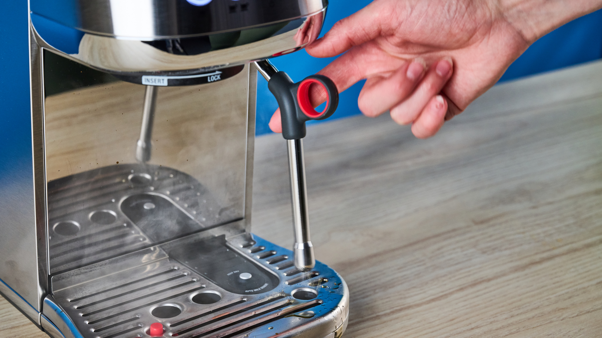 the breville bambino plus / sage bambino plus in stainless steel silver photographed against a blue background shown with its accessories including milk jug, tamper, portafilter, and shown in use extracting espresso