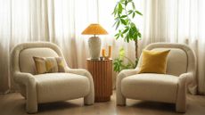 a wireless table lamp between two arm chairs