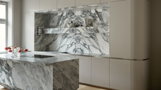 sleek modern kitchen with marble island and backsplash