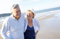 Happy senior couple walking on beach