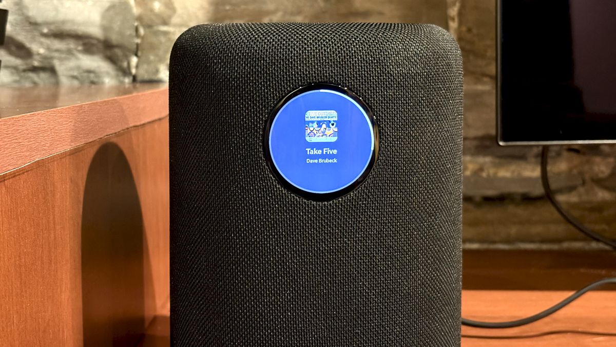 The WiiM Sound, in a home, on a varnished wooden table, showing the illuminated front panel