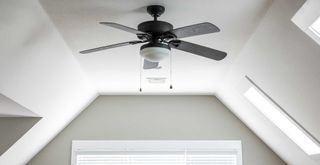 ceiling fan in a white bedroom to demonstrate fan hack to make it more efficient in summer