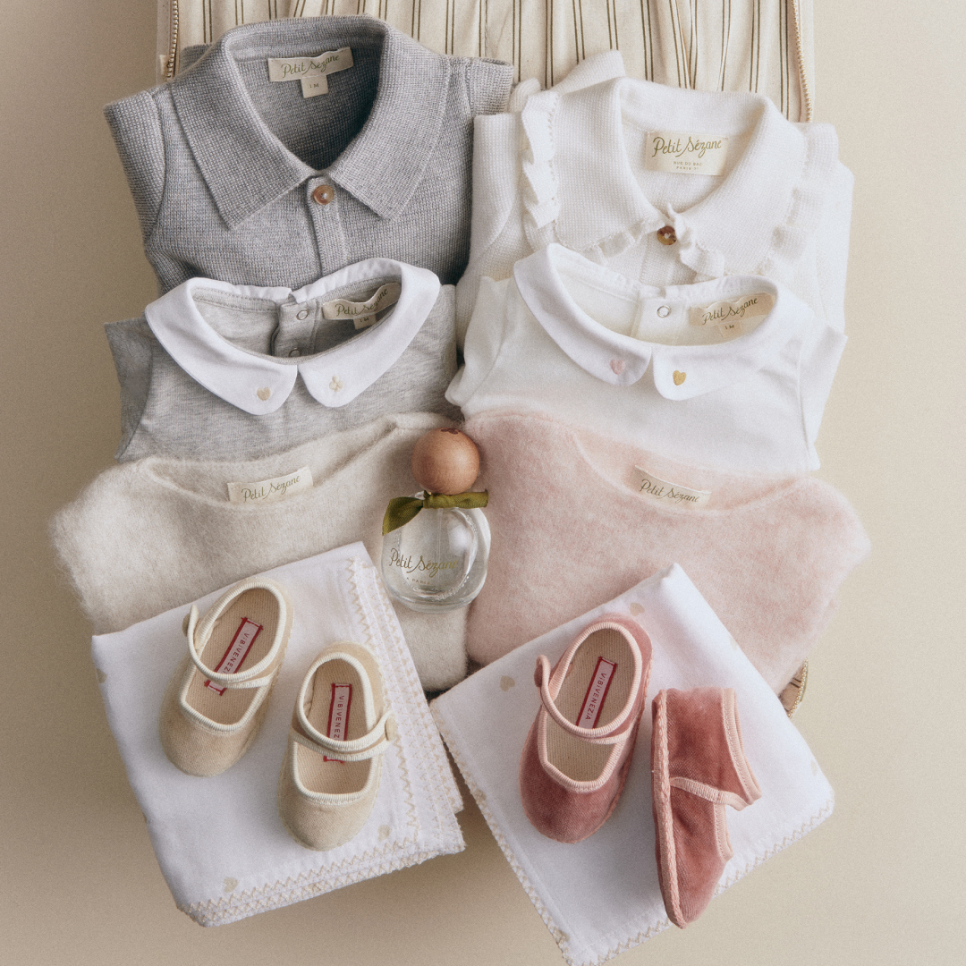 a collection of S&eacute;zane newborn clothes in a gift box