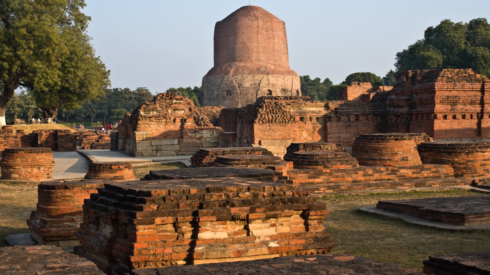 This photo shows the Dhamekh stupa in India. It is a tall mound-like structure.