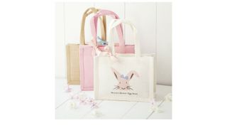 Three jute bags - one in brown, one in pale pink and one in white. The white one at the front of the image features a cartoon Easter bunny with Emma's Easter Egg Hunt printed on it.