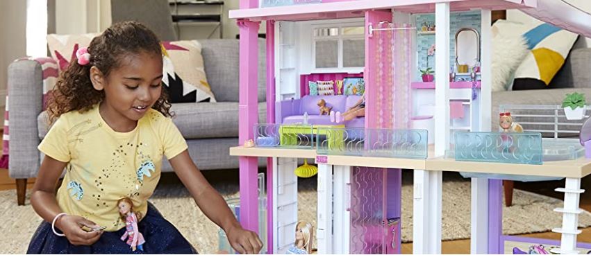 An image of a little girl playing with the Barbie Dreamhouse