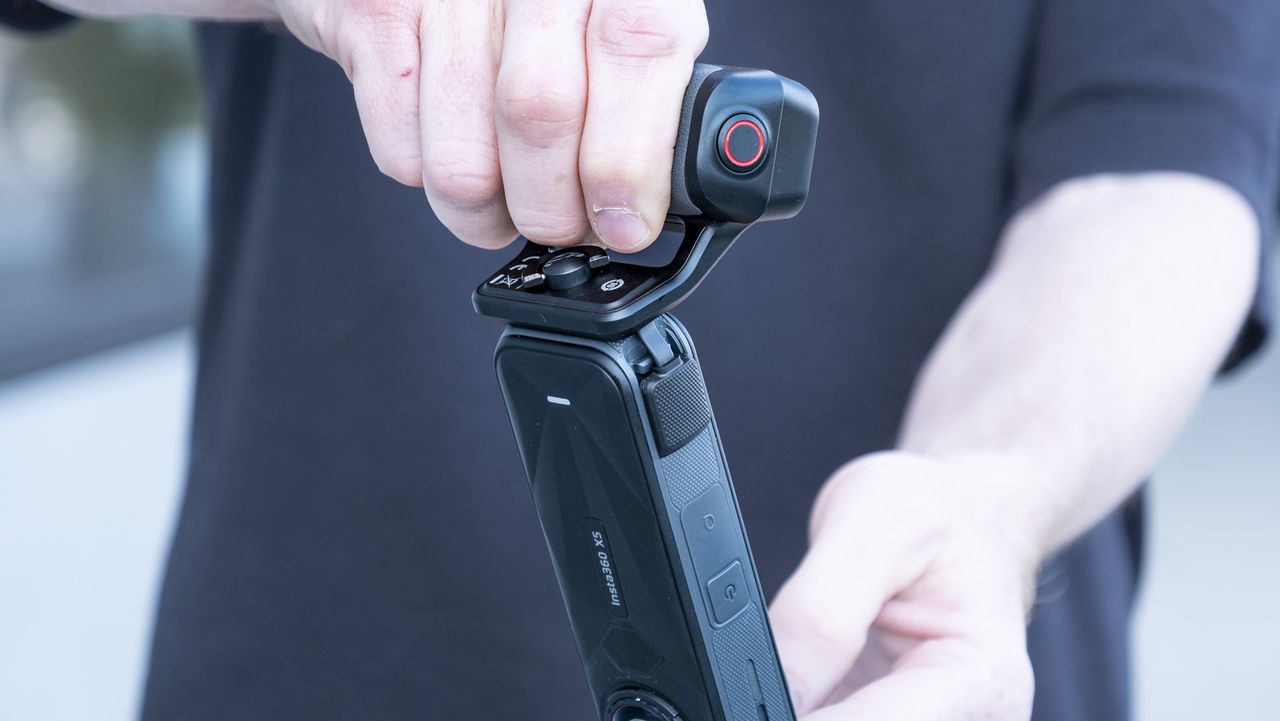 Insta360 X5 Photography Grip attached to the camera, in the hand