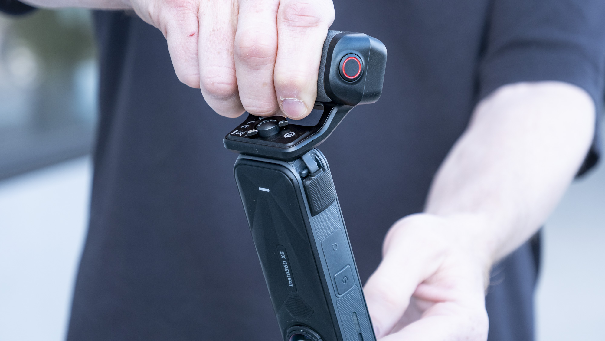 Insta360 X5 Photography Grip attached to the camera, in the hand
