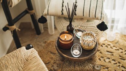A collection of scented candles in warm neutral jars on a round side table