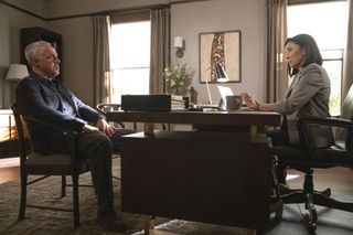 Harry Bosch (Titus Welliver) sits with Honey Chandler (Mimi Rogers) in her office in a large LA house. Honey is on one side of the desk in an office chair, with her laptop open and a coffee mug on the table, Harry sits in a dining chair on the other side. The room is tastefully decorated with a work of art on the wall behind both of them, and sunlight is pouring through the windows.
