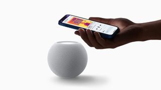 An Apple HomePod mini with an iPhone playing music