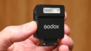 Godox iM22 product shot, held in hand