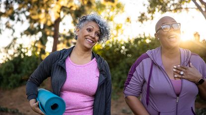 Women in workout clothing holding yoga mat