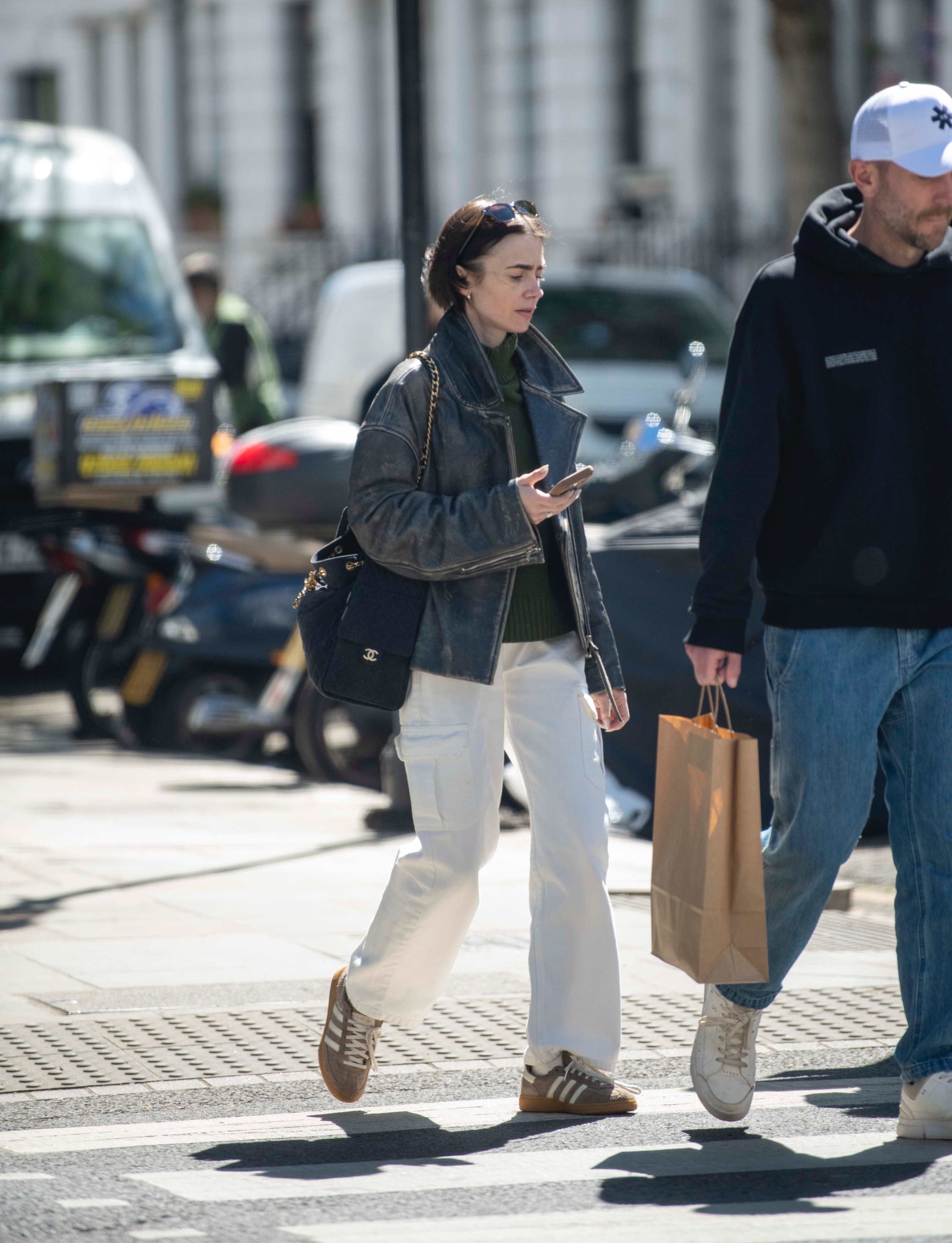 Lily Collins styling a Chanel bag with Adidas sneakers and white jeans