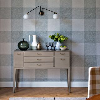 Blue grey gingham accent wallpaper with console table and gingham chair