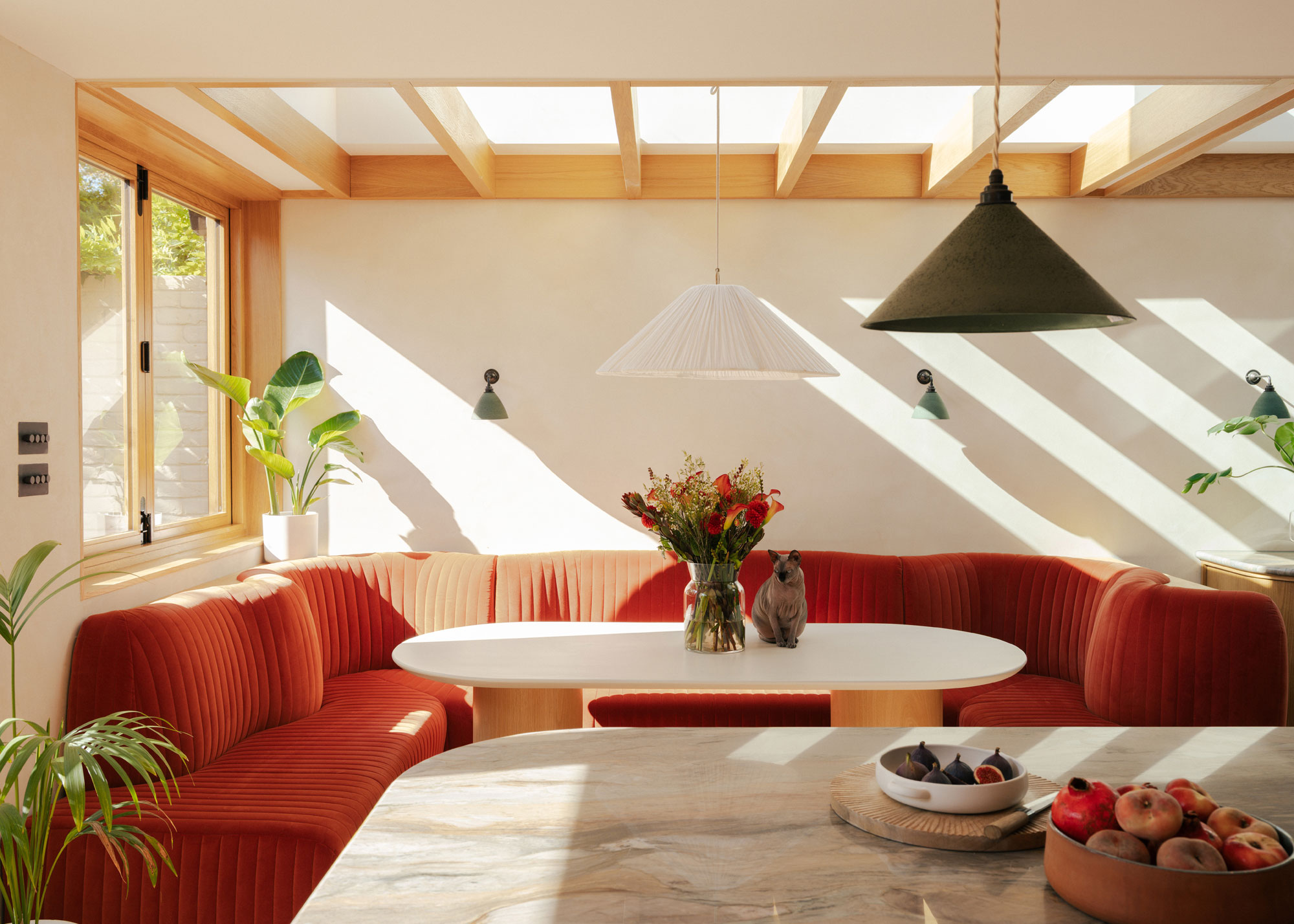 red padded banquette seating in small kitchen extension
