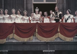 Queen Elizabeth II and the Duke of Edinburgh wave at the crowds from the balcony of Buckingham Palace in London, after Elizabeth's coronation, 2nd June 1953