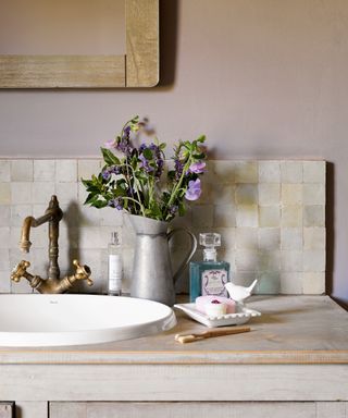 Brass tap on countertop with flower