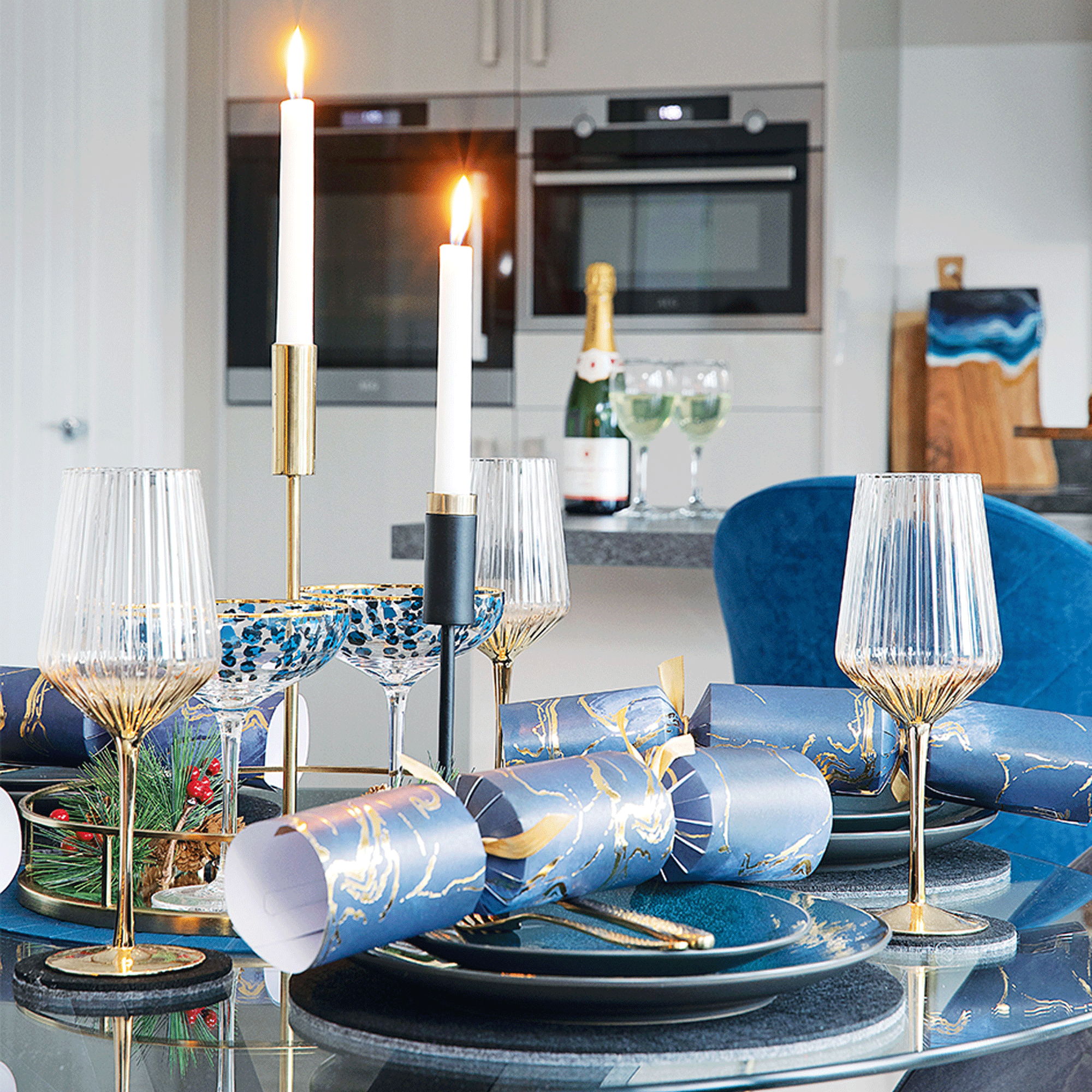 Glass table with candle sticks and blue chairs