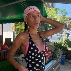a woman wearing a pink crotchet cap and polka dot swimsuit