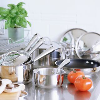 A kitchen worktop with stainless steel pots and pans
