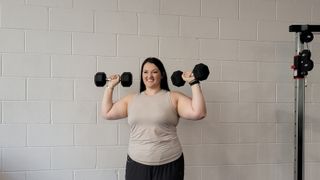 Personal trainer Rebecca Stewart demonstrates a standing shoulder press move