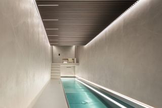 long lap pool inside home with textured plaster