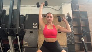 Woman doing a squat and press with dumbbells