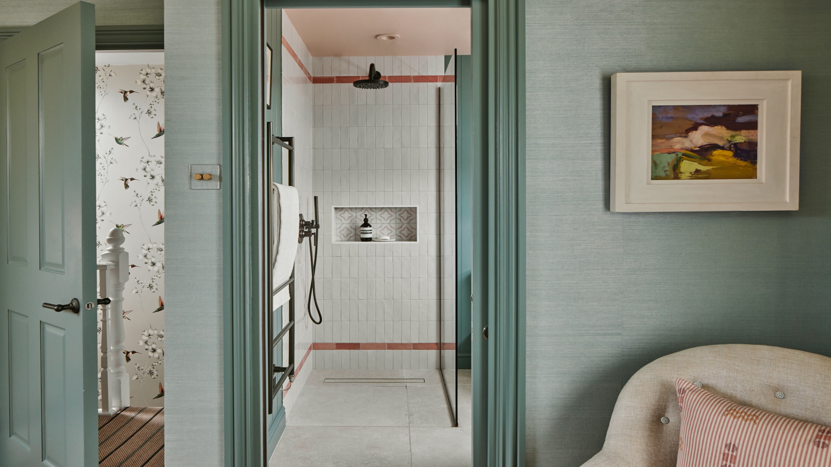 A guest bathroom with white tiling as an en suite in a teal colored guest bedroom 