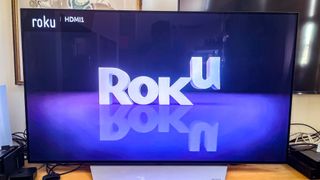 The bouncing Roku logo on a TV attached to the Roku Express (2022)