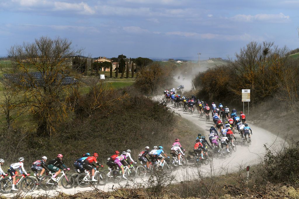 SIENA ITALY MARCH 05 The peloton passing through a gravel strokes sector during the Eroica 16th Strade Bianche 2022 Mens Elite a 184km one day race from Siena to Siena Piazza del Campo 321m StradeBianche WorldTour on March 05 2022 in Siena Italy Photo by Tim de WaeleGetty Images