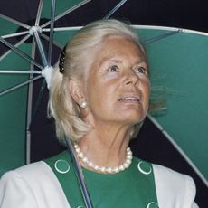 The Duchess of Kent carries a green and black umbrella which coordinates with her white and green dress