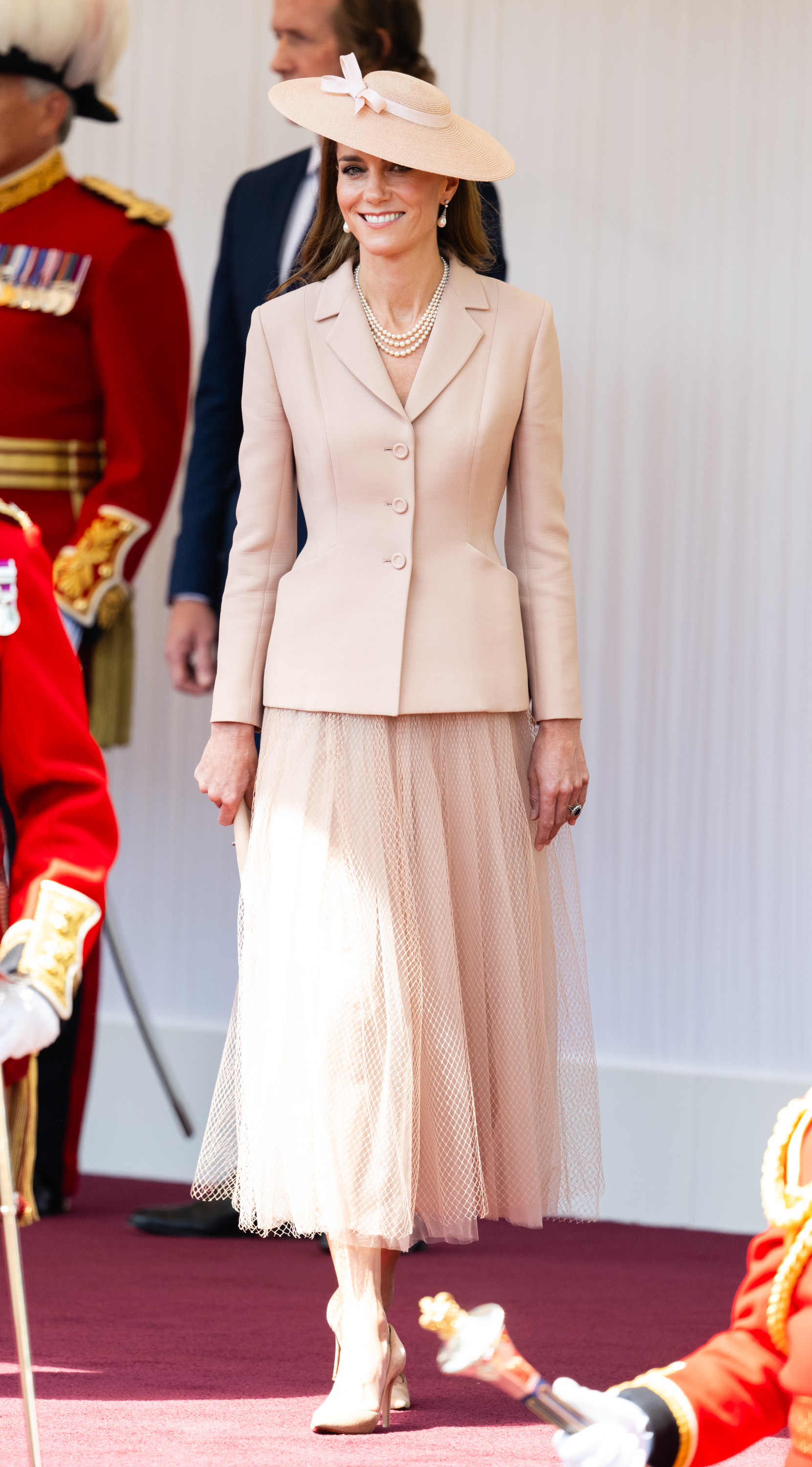 Kate Middleton in a pink jacket and skirt smiling