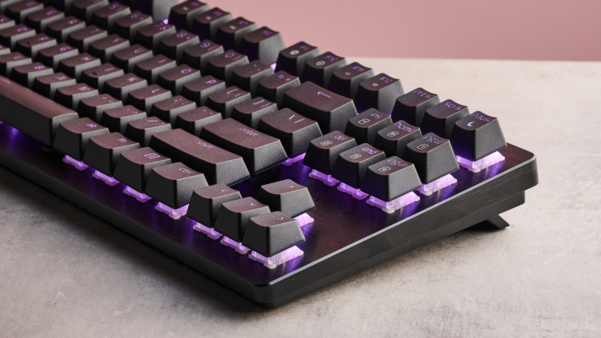 Three-quarter view of right-hand portion of Razer Huntsman V3 HE Magnetic Tenkeyless 8KHz, on a desk with pink wall in background