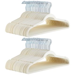 Two stacks of beige velvet hangers with silver hooks