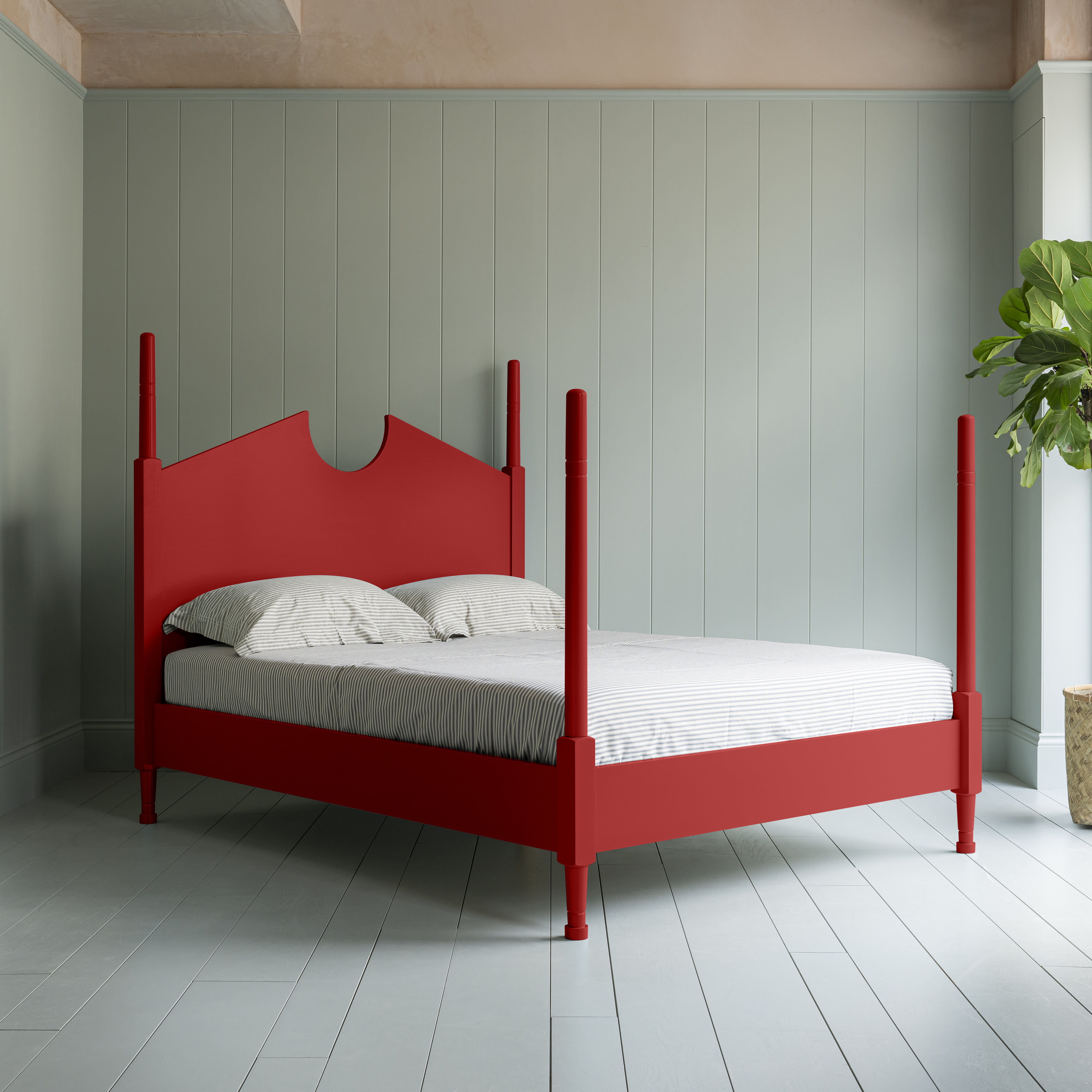 Red four-poster bed in a clapboard clad room