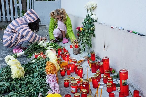 Women light candles by scene of Romanian nightclub fire