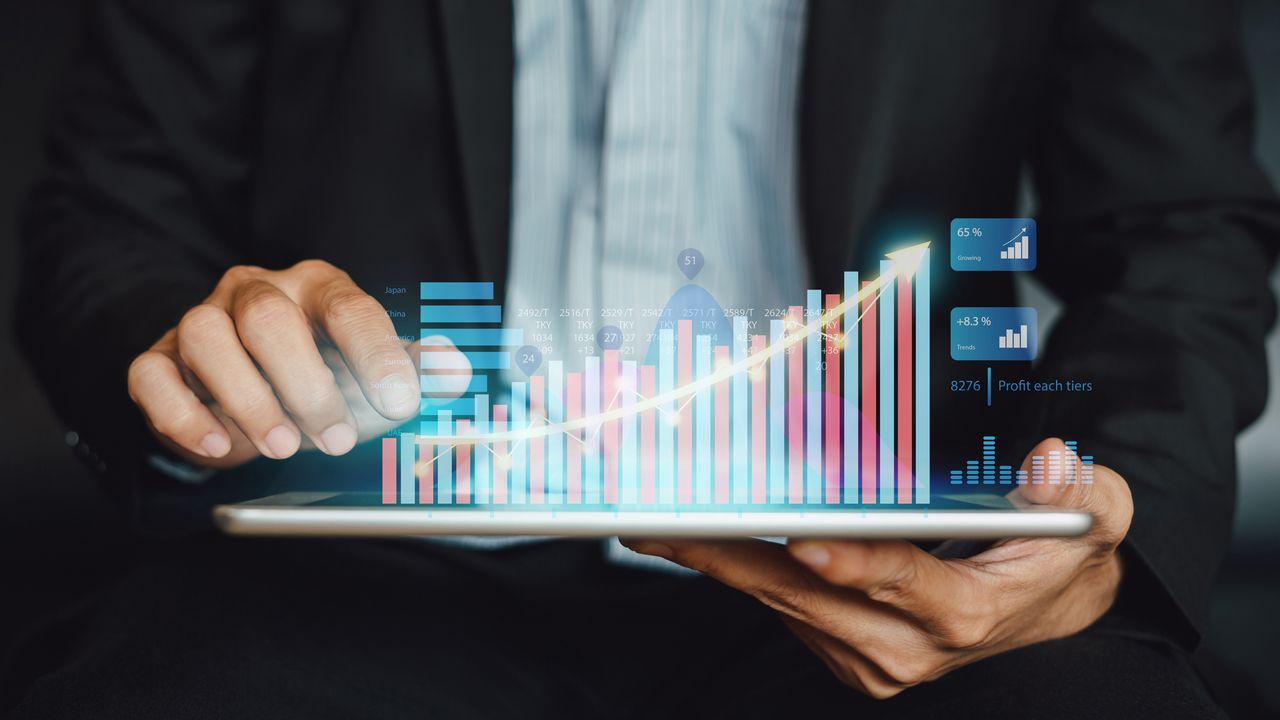 Man in suit holding tablet with graph visualisation hovering above it