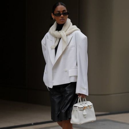 @cherifaakili wears white cropped blazer, leather shorts, white heels, scarf, bag and black sunglasses