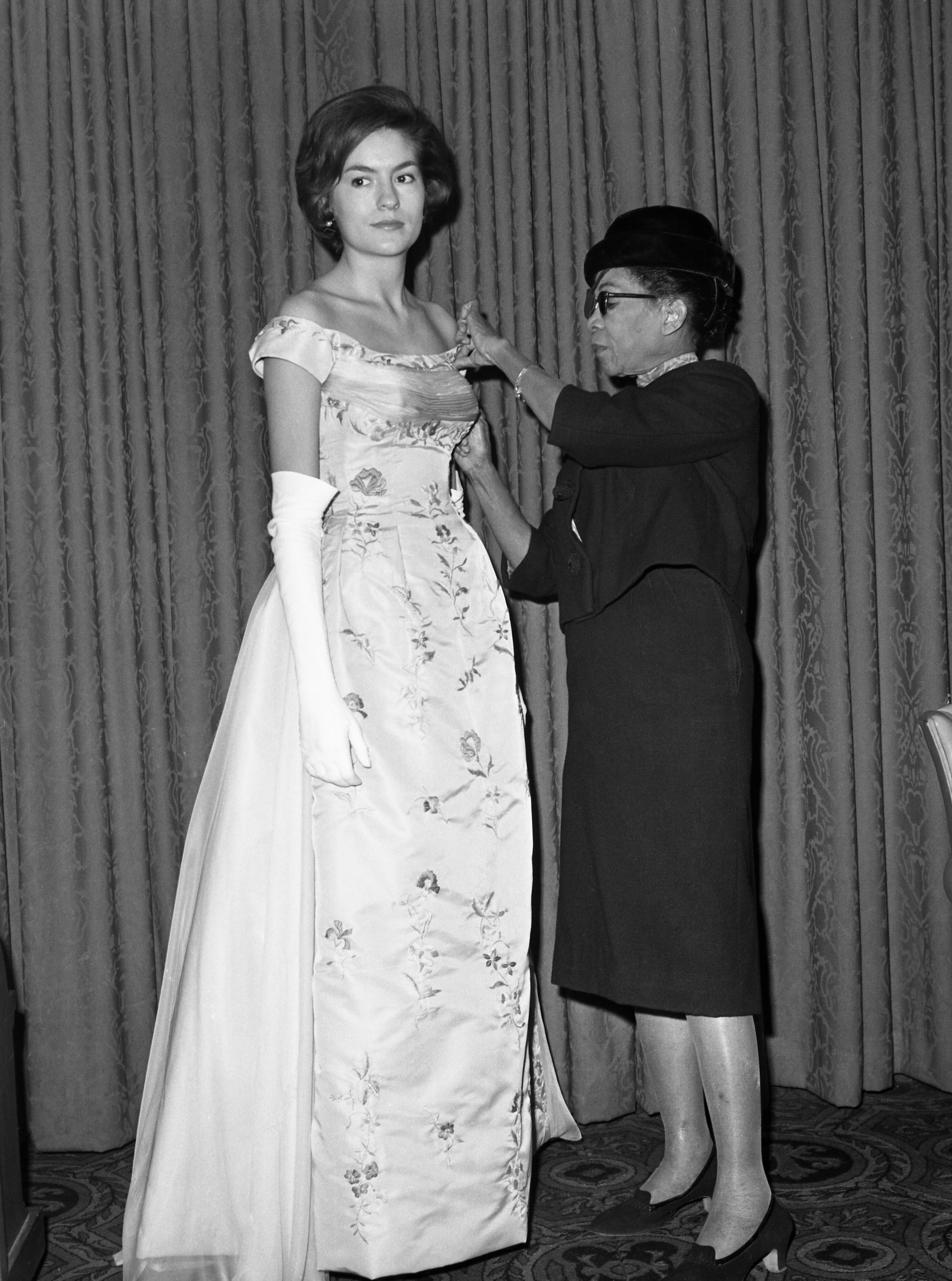 Ann Lowe adjusts a dress on a model