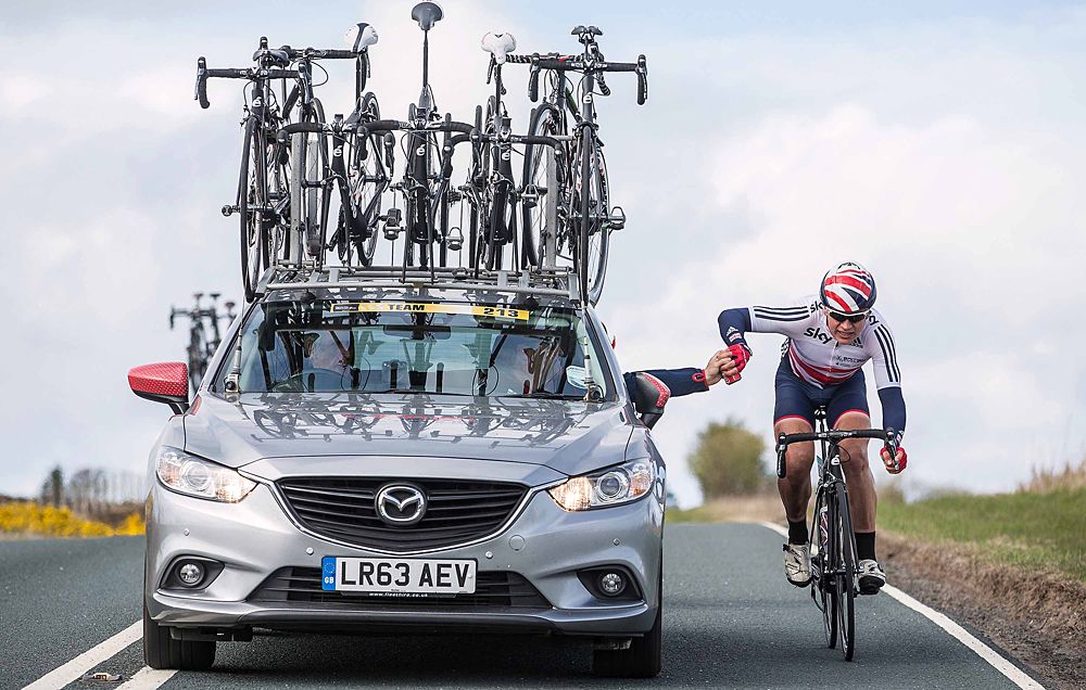 Rider taking a feed from the team car