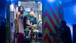 Maryam (Parminder Nagra) and Catherine (Lara Pulver) dressed up in gowns in the back of an ambulance in Maternal